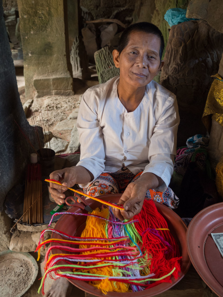 Temple worker selling bracelets, Cambodia